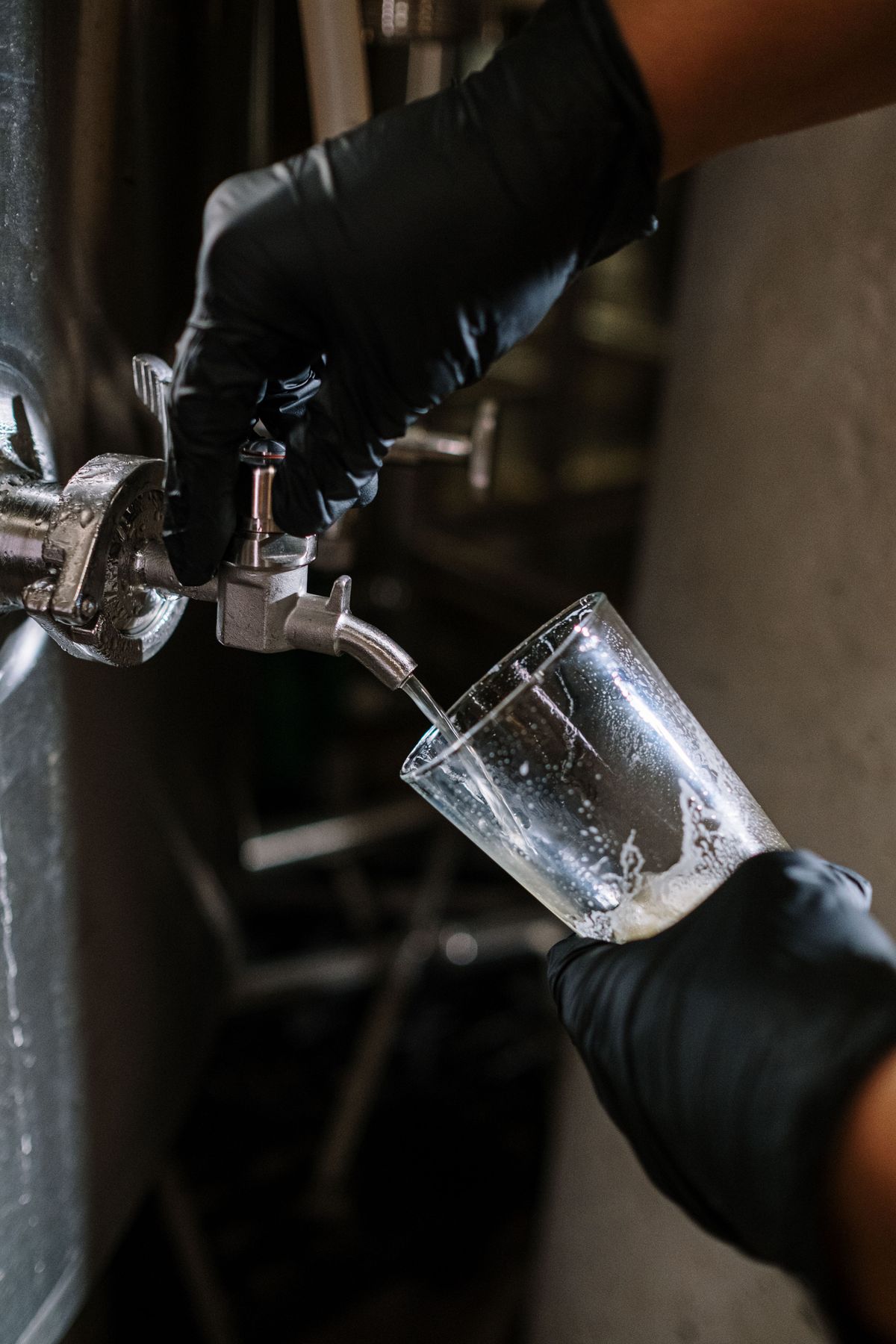 Cervejeiro da Beiço de Pulga tirando chope direto do tanque na fábrica